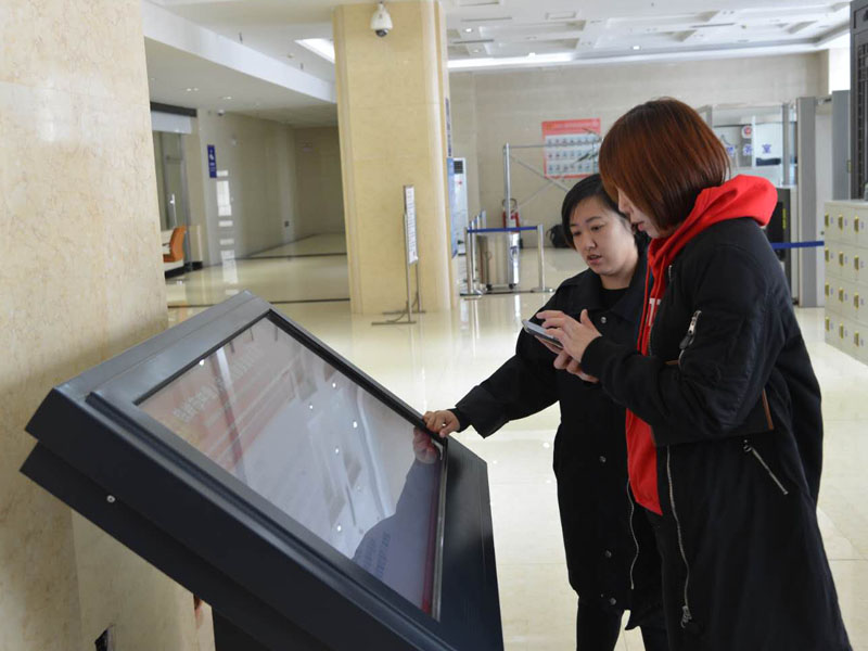 圖三，赫媛媛向記者介紹自助查詢機(jī)