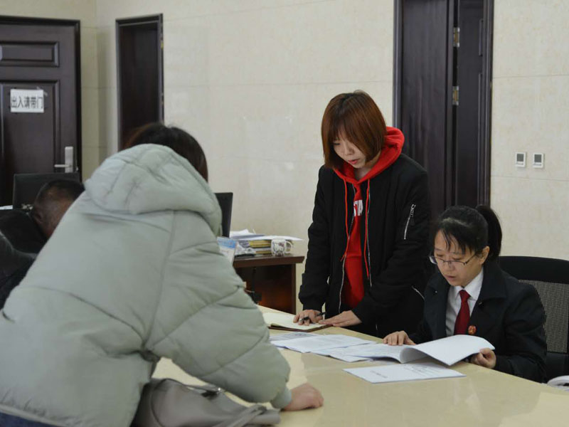 圖四，記者和劉璐一起在立案窗口接待辦事人