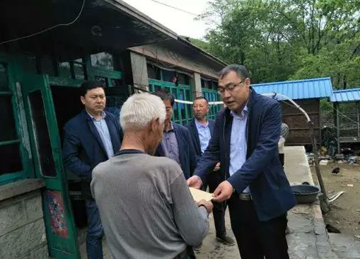 金龍（右一）探望貧困村民