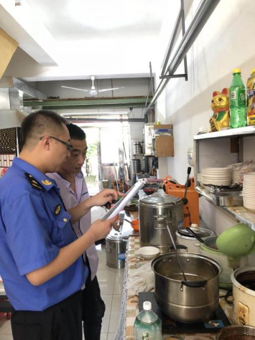 綜合執(zhí)法人員對(duì)餐飲企業(yè)進(jìn)行油煙污染檢查