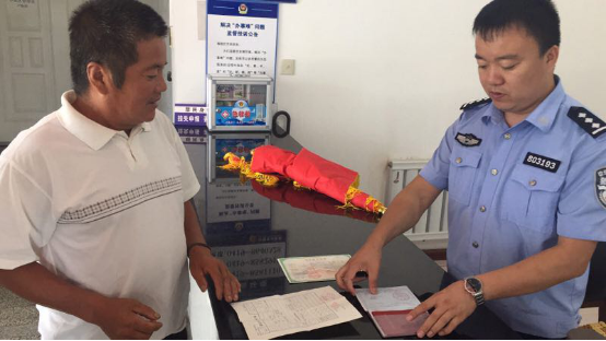 王賀（右）在為群眾辦理戶(hù)籍手續(xù)