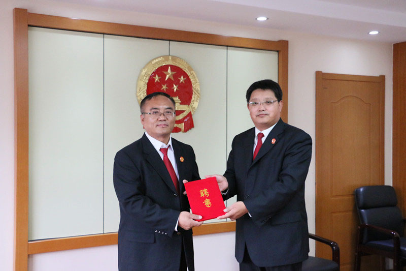 錦州市太和區(qū)人民法院黨組書記、院長康贏健(右)為新任法官導(dǎo)師頒發(fā)了聘書