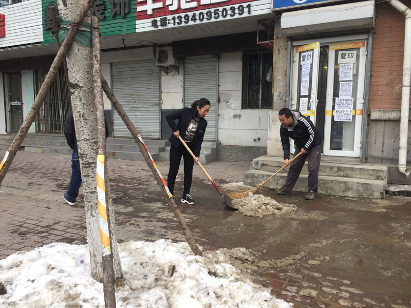 記者和網(wǎng)格員清理積冰
