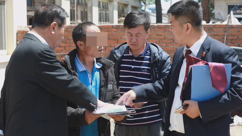 擋臉！第二稿配圖：執(zhí)行法官及工作人員為被執(zhí)行人解釋生效文書內(nèi)容并督促其騰房