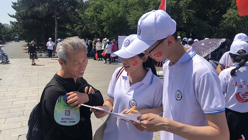 志愿者向市民發(fā)放調(diào)查問卷