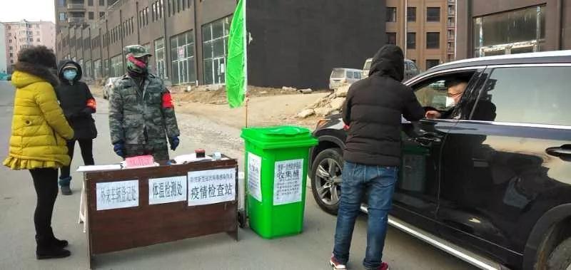 社區(qū)工作人員檢查過往車輛