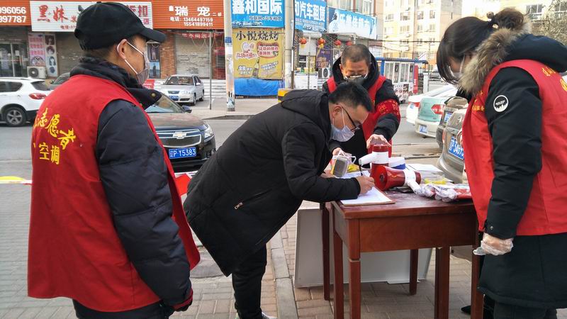 在小區(qū)門口檢疫點(diǎn)對外來人員進(jìn)行登記