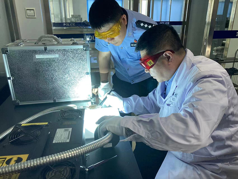 丁友（左）與同事在實驗室對現(xiàn)場提取的指紋進行反復比對