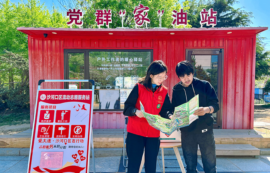 （頭題配圖）志愿者在大連沙河口區(qū)流動志愿服務站服務游客