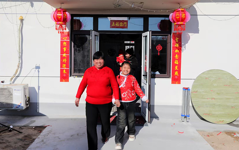 綏中縣明水滿族鄉(xiāng)祝家溝村村民在新房前