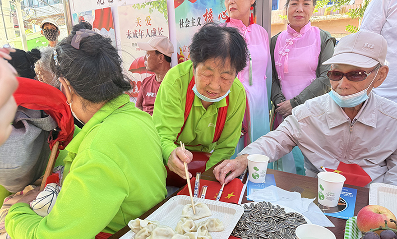 5圖，志愿者為老人包餃子歡度節(jié)日