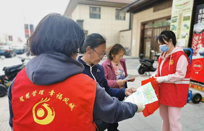 丹東圖，志愿者向居民發(fā)放建設(shè)文明小區(qū)傳單