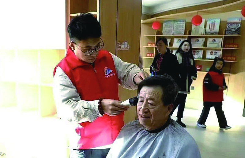 3美發(fā)師志愿者小王正在為獨(dú)居老人張大爺理發(fā)。