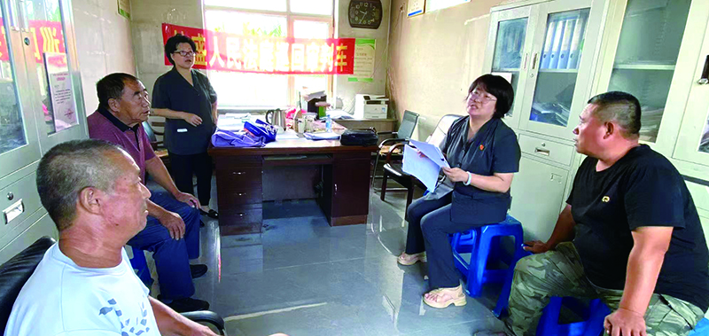 劉芳庭長（右二）在八一紅菱街道某村講解土地承包相關(guān)法律法規(guī)