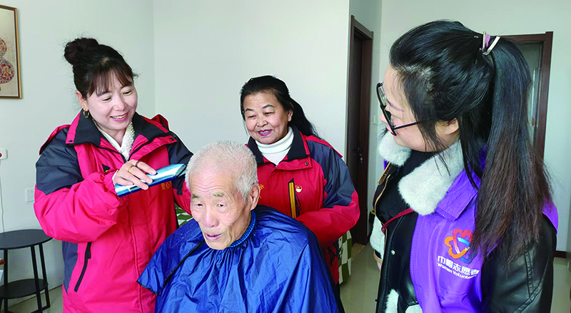 二題圖，專業(yè)社工帶領志愿者們上門為居民義剪