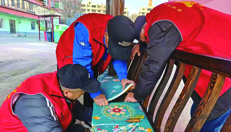 二題圖，社區(qū)志愿者為連廊座椅加鋪軟墊