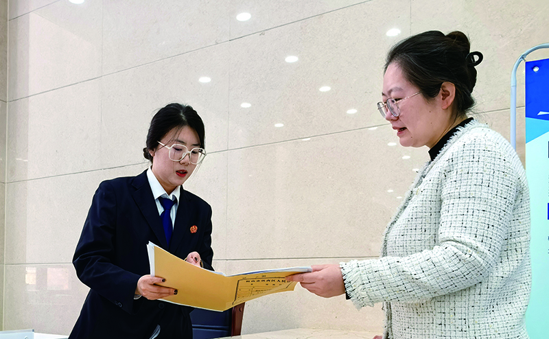 訴服中心的涉企案件綠色通道窗口，法官助理張嘉鑫正耐心指導(dǎo)當(dāng)事人填寫訴答文書