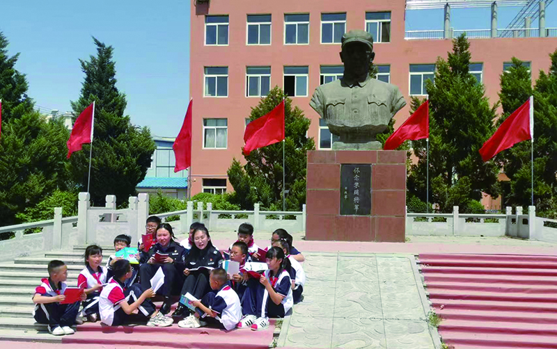 頭題圖，普法志愿者在愛國主義教育基地為學(xué)生們普法。